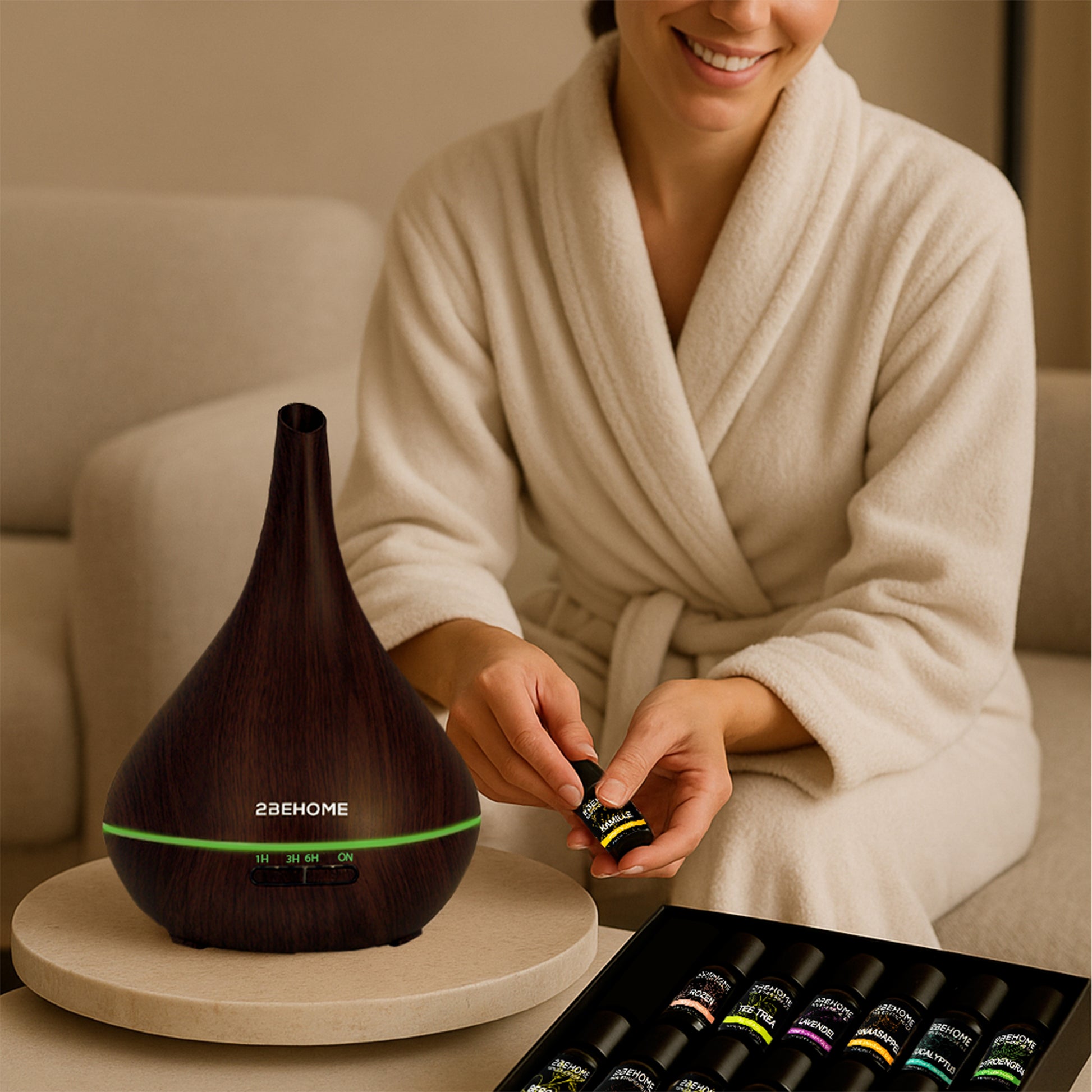 Vrouw gebruikt aroma diffuser luchtbevochtiger op de bank en laat een flesje met etherische olie zien.