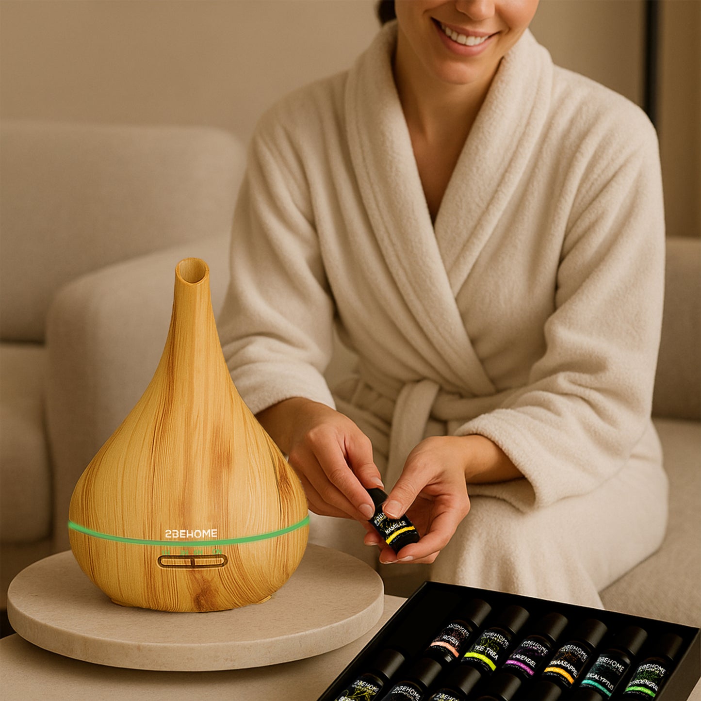 Vrouw gebruikt aroma diffuser luchtbevochtiger op de bank en laat een flesje met etherische olie zien.