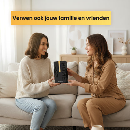 Twee vrouwen zitten op de bank terwijl één van hen een 2BEHOME geurkaars en geurstokjes giftset cadeau geeft.